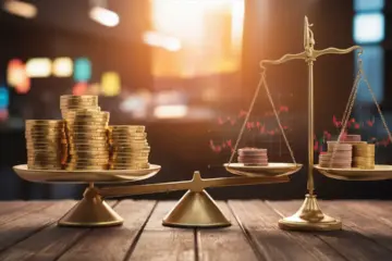 Scales with gold coins and stock market graphs balanced on a wooden table.